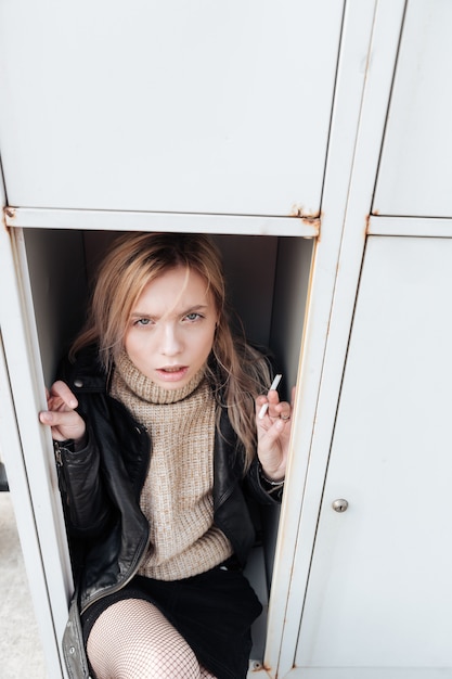 Kostenloses Foto ernsthafte junge blonde dame, die im safe sitzt