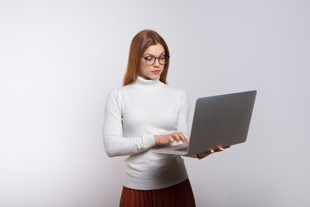 Ernsthafte junge Geschäftsfrau mit Laptop