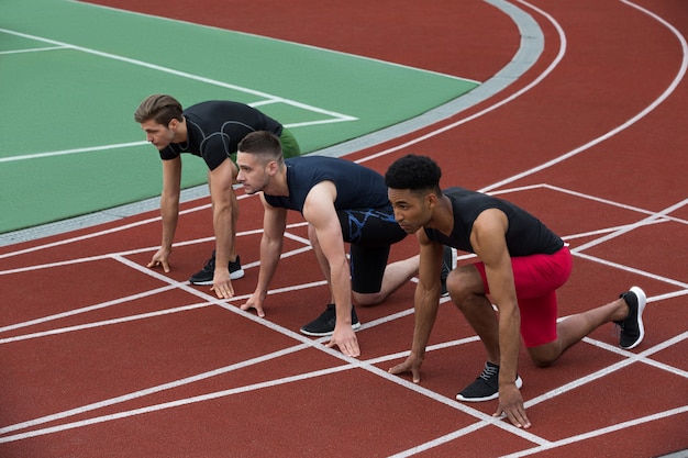 Ernsthafte multiethnische Athletengruppe bereit zu laufen