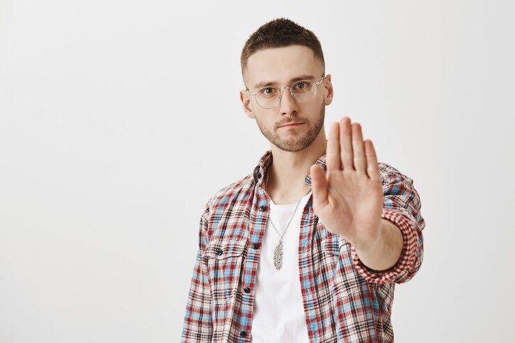 Kostenlose Foto ernsthafter unzufriedener junger mann mit brille posiert