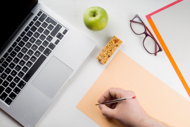 Ernte Handschrift in der Nähe von Laptop und Apple