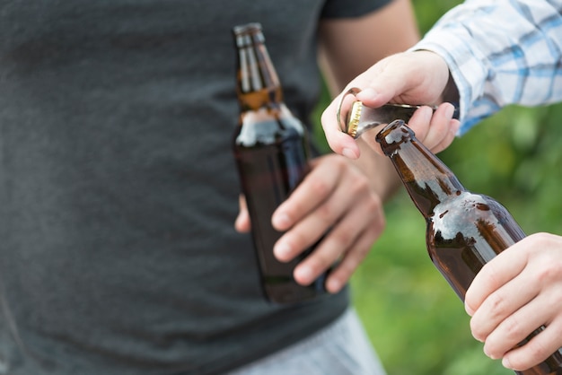 Ernte Männer, die Bier in der Natur öffnen