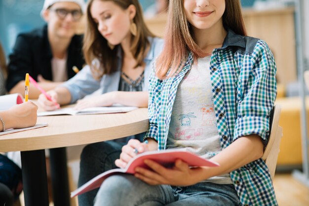 Ernte Schulmädchen sitzen mit Studien auf Stuhl