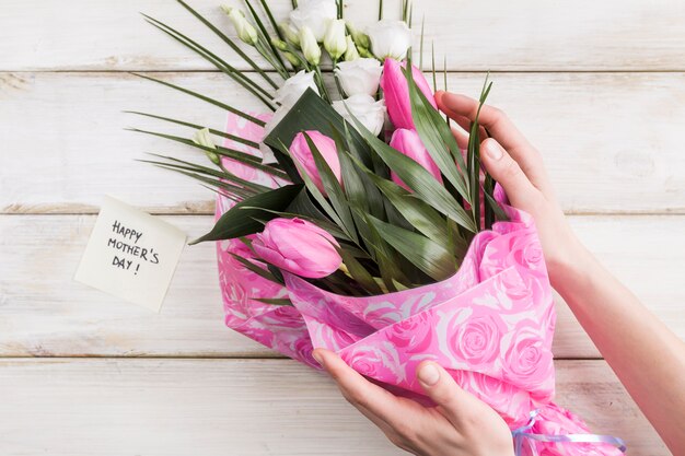 Erntefrau, die Blumenstrauß von Blumen hält