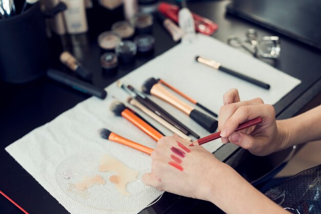 Erntefrau, die Lippenstifte an Hand versucht