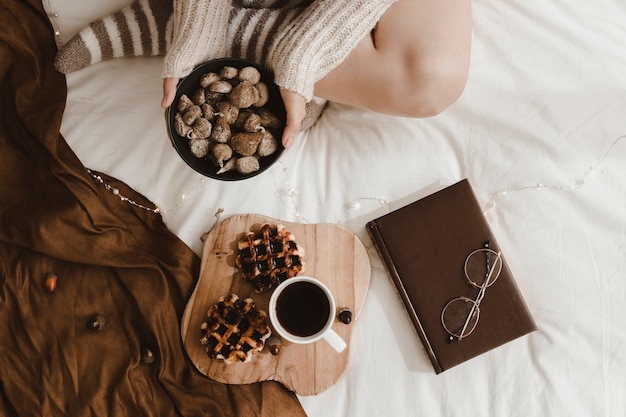 Kostenloses Foto erntefrau mit snack nahe nachtisch und buch