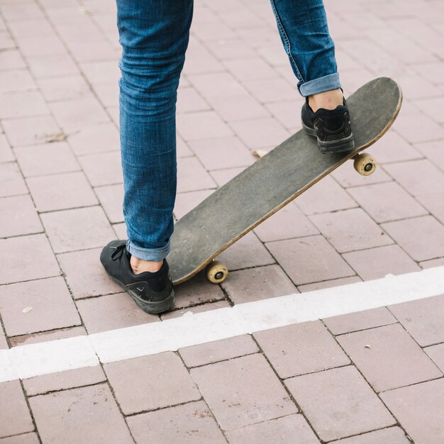 Erntejugendlicher, der Bremsung auf Skateboard durchführt