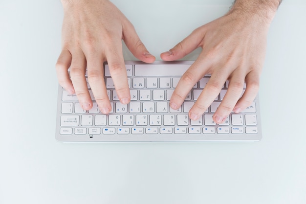 Ernten Sie die Hände, die auf kleiner Tastatur schreiben