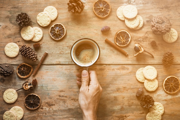 Ernten Sie die Hand, die Kaffee nahe Gewürzen hält