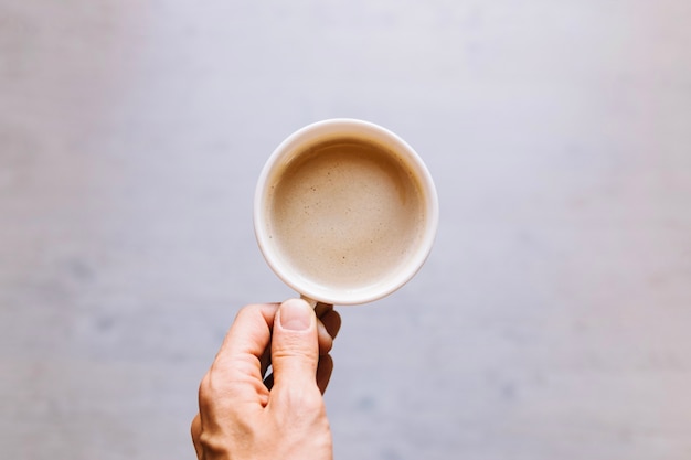 Ernten Sie die Hand, die Tasse Kaffee hält