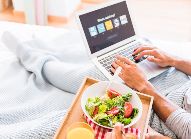 Ernten Sie ein Paar, das Salat isst und ein Streaming-Dienstkonto wählt