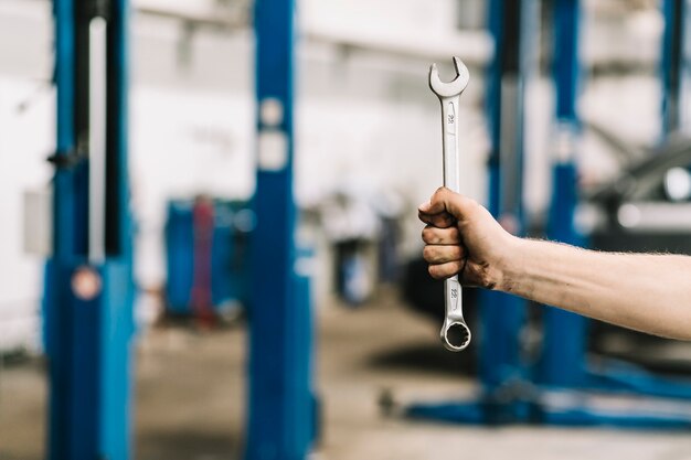 Ernten Sie Hand mit Schlüssel in der Werkstatt