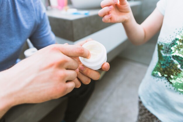 Erntevater, der Creme für Tochter nimmt