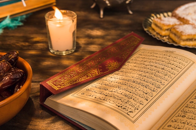 Eröffnet Quran in der Nähe von Kerzen und süßen Datteln