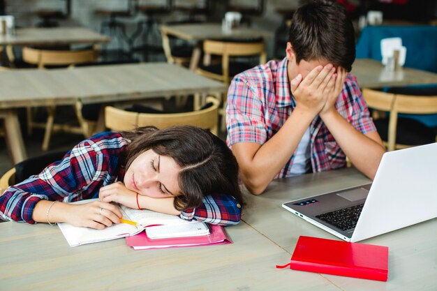 Erschöpfte Studenten am Desktop