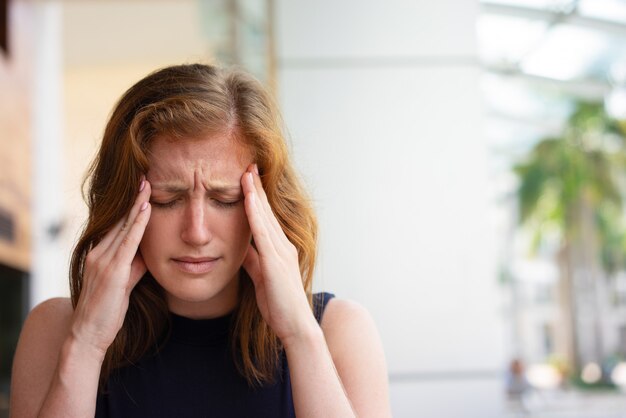 Erschöpfter Büroangestellter, der unter Kopfschmerzen leidet
