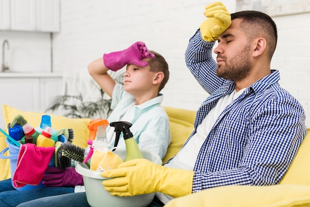 Erschöpfter Vater und Sohn ruhen auf der Couch