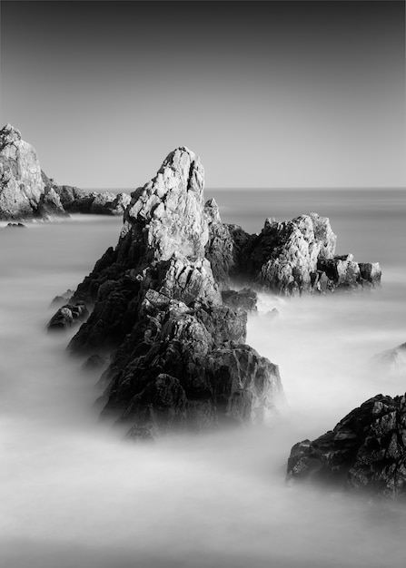 Erstaunliche Graustufenaufnahme eines felsigen Strandes in Guernsey