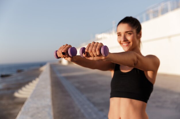 Erstaunliche junge glückliche Sportfrau machen Sportübungen