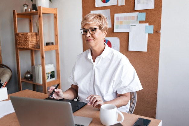 Kostenloses Foto erwachsene designerin arbeitet mit laptop in ihrem büro