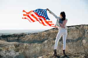 Kostenloses Foto erwachsene frau, die hände mit usa-flagge anhebt