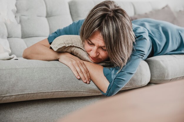 Erwachsene Frau, die zu Hause betont