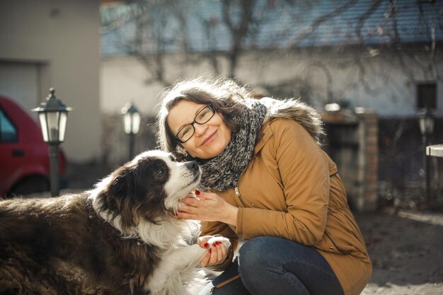 erwachsene Frau im Garten mit ihrem Hund