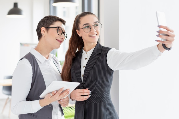 Erwachsene Frauen machen ein Selfie im Büro