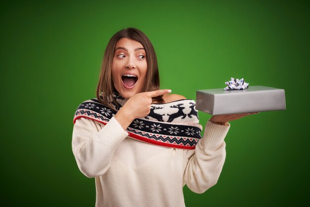 Erwachsene glückliche frau mit weihnachtsgeschenk über grünem hintergrund Premium Fotos