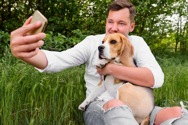 Erwachsener Mann, der ein Selfie mit seinem Hund nimmt