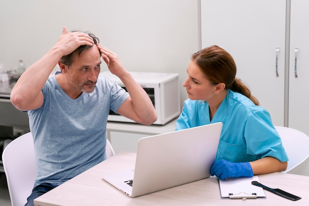 Kostenloses Foto erwachsener mann, der eine haarausfallbehandlung erhält