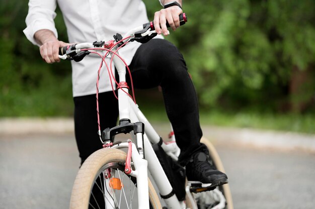 Erwachsener Mann, der modernes Fahrrad draußen reitet