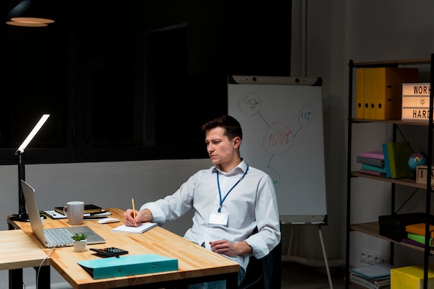 Erwachsener Mann, der nachts von zu Hause aus arbeitet