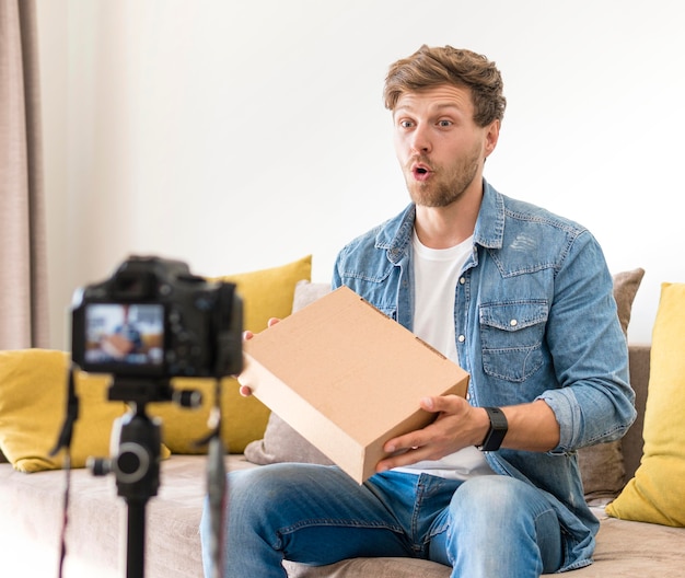 Erwachsener Mann, der Unboxing-Video für Blog aufzeichnet