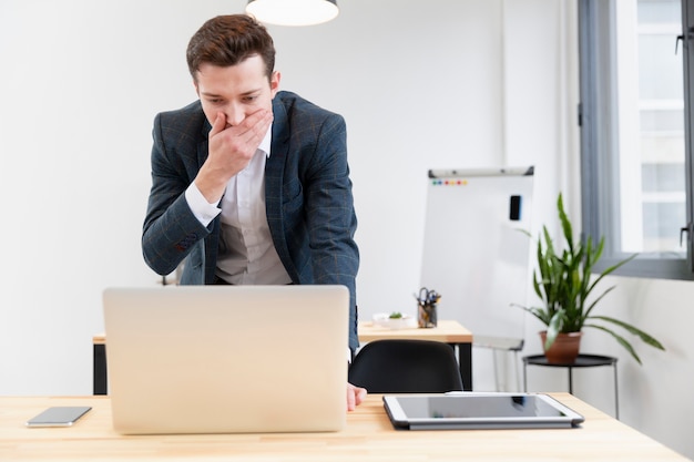 Erwachsener Mann der Vorderansicht, der im Büro arbeitet