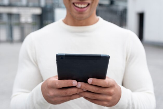 Erwachsener Mann des smiley, der eine Tablette hält