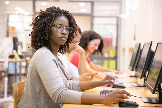 Erwachsener Student der schwarzen Frau, der in der Computerklasse arbeitet