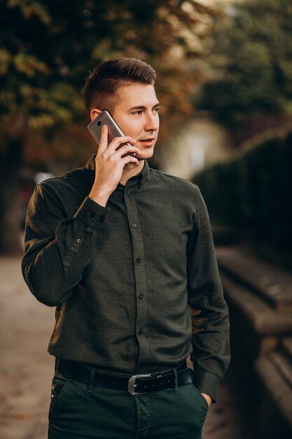 Erwachsener Student des jungen Mannes, der am Telefon spricht