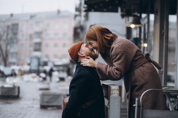 Erwachsenes liebevolles Paar, das auf einer Straße küsst