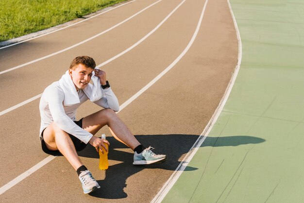 Es ist eine Totale zu sehen, wie der Läufer eine Pause macht