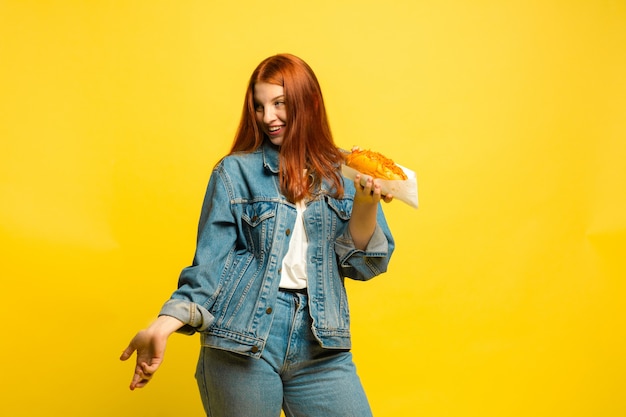 Es ist einfacher, Anhänger zu sein. Sie müssen nicht mit Essen fotografieren. Kaukasische Frau ist auf gelbem Hintergrund. Schönes weibliches rotes Haarmodell. Konzept der menschlichen Emotionen, Gesichtsausdruck, Verkauf, Anzeige.