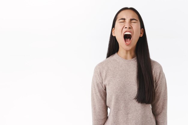 Es satt, empört, dummer ostasiatischer unruhiger Teenager, der schreit, belästigt, arrogant ist, mit offenem Mund laut schreit, die Augen schließt, jammert, sich beschwert, hat nichts gebracht