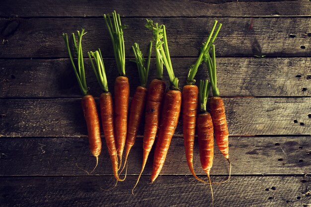 Essen Bio-Gemüse Bunte Hintergrund. Leckere frische Karotten auf Holztisch. Draufsicht mit Kopierraum. Gesundes Lebenskonzept.