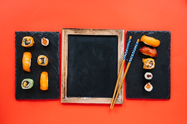 Essstäbchen auf Tafel zwischen Sushi-Boards