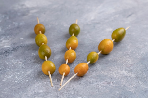 Essstäbchen mit frischen kumquats auf marmor.