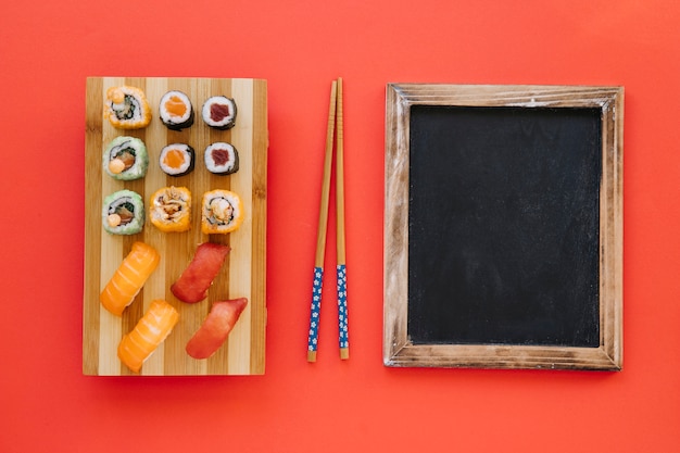 Kostenloses Foto essstäbchen zwischen rollen und tafel