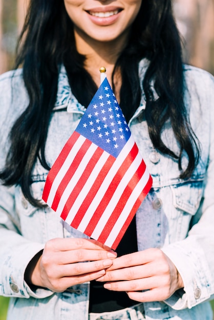 Ethnische Frau, die amerikanische Flagge hält