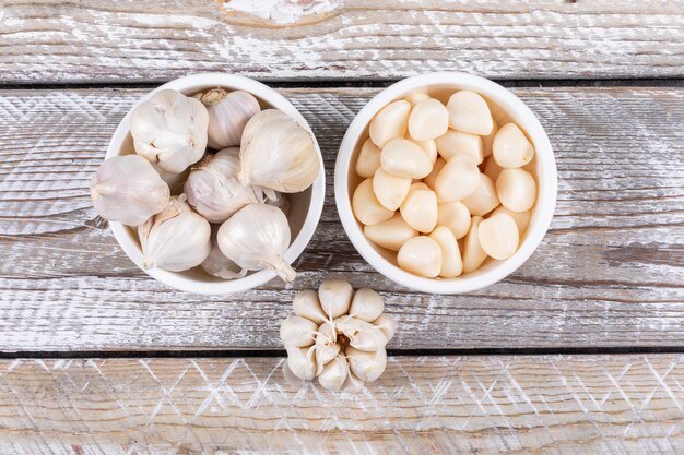 Etwas Knoblauch in einer Schale und in der Nähe auf Holztisch, Draufsicht.