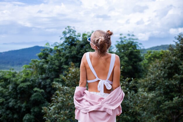 Europäische stilvolle Frau Touristin steht auf der Spitze des Berges mit erstaunlicher tropischer Ansicht der Koh Samui Insel Thailand Mode-Außenporträt der Frau