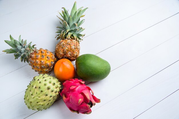 Exotische frische sommerfrüchte auf weiß. drachenfrucht, ananas ...